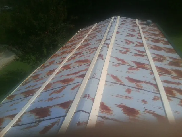 Rusted metal roof panels with new wood purlins before replacement — Storm Damage Roof Repair in Ashland City by Roofing Brothers